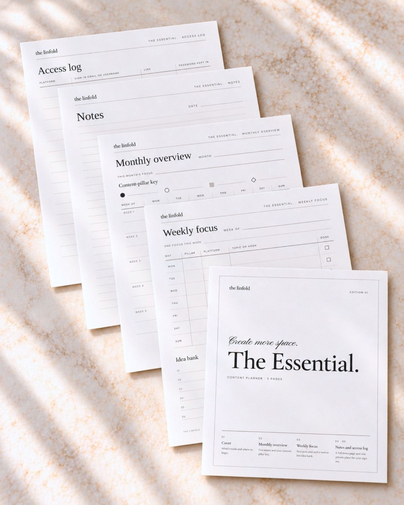 The Essential. planner pages fanned out on marble